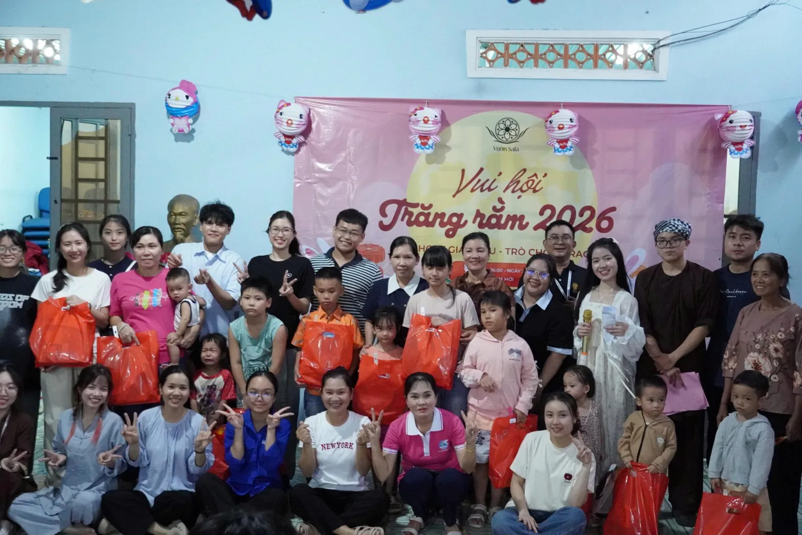 孩子们手持中秋礼物,在“Vui hội Trăng rằm 2026”横幅前与主办方合影