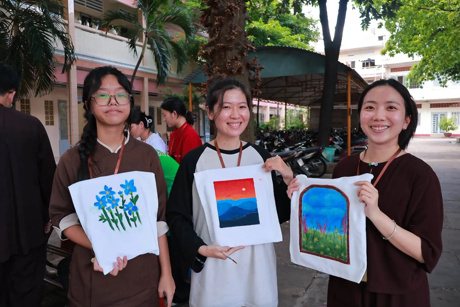 三位学员展示亲手彩绘的布袋