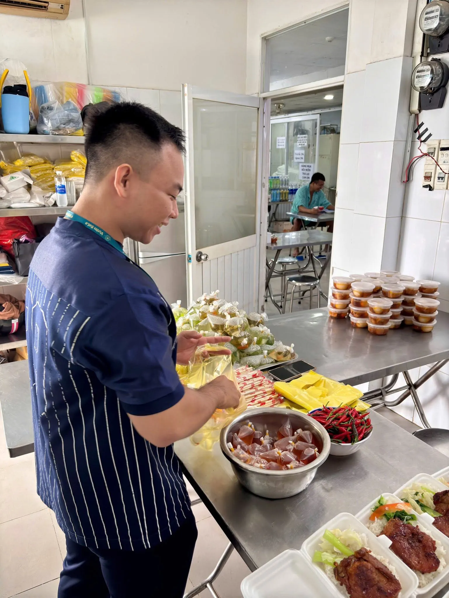 A volunteer preparing food at a stainless-steel counter