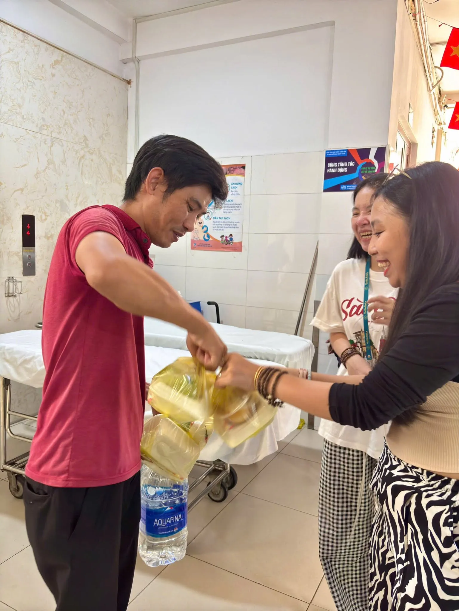 Volunteers handing a bag of meals to a man in the hospital
