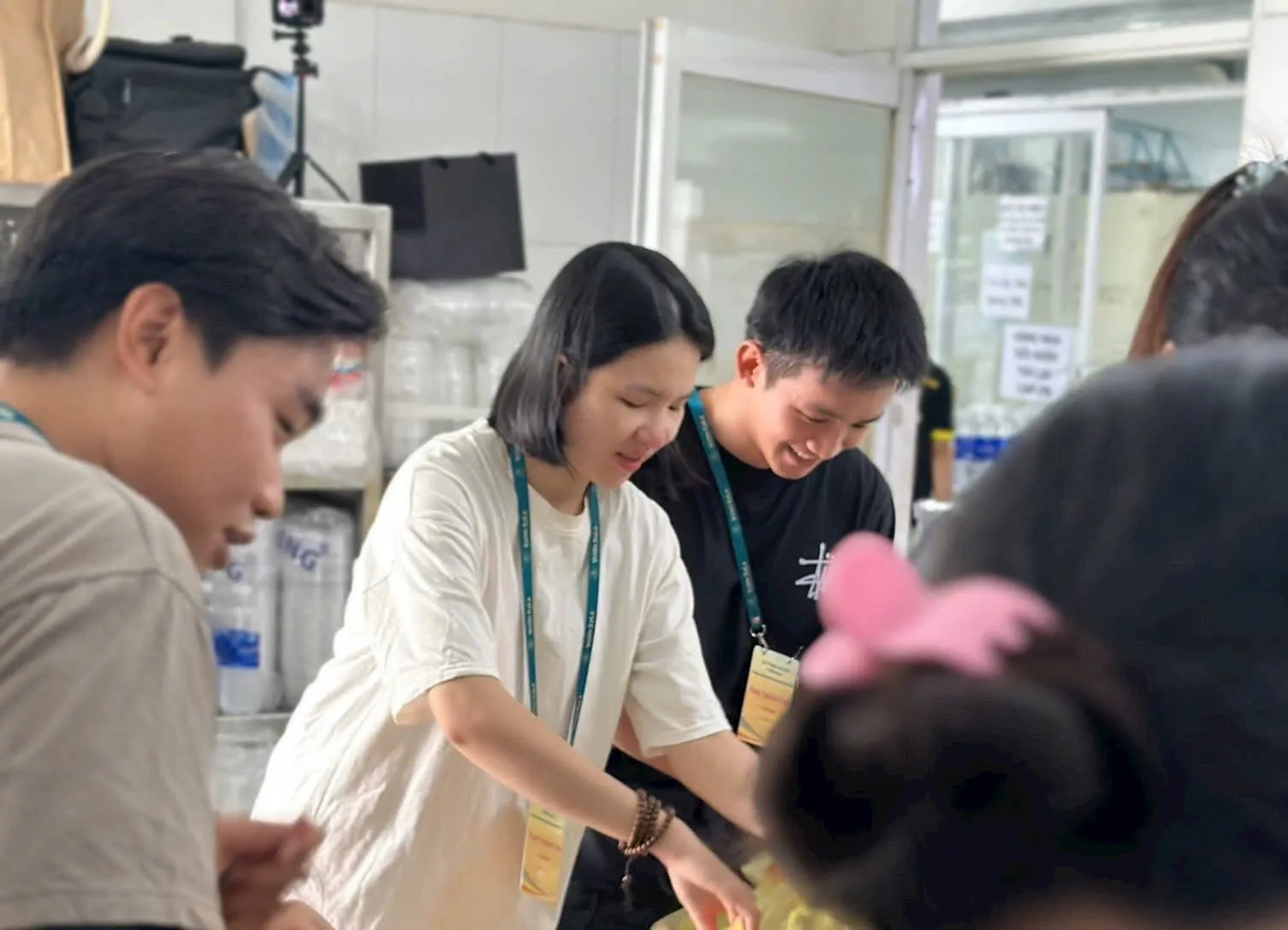 Các bạn tình nguyện viên tươi cười khi cùng nhau chuẩn bị các phần ăn