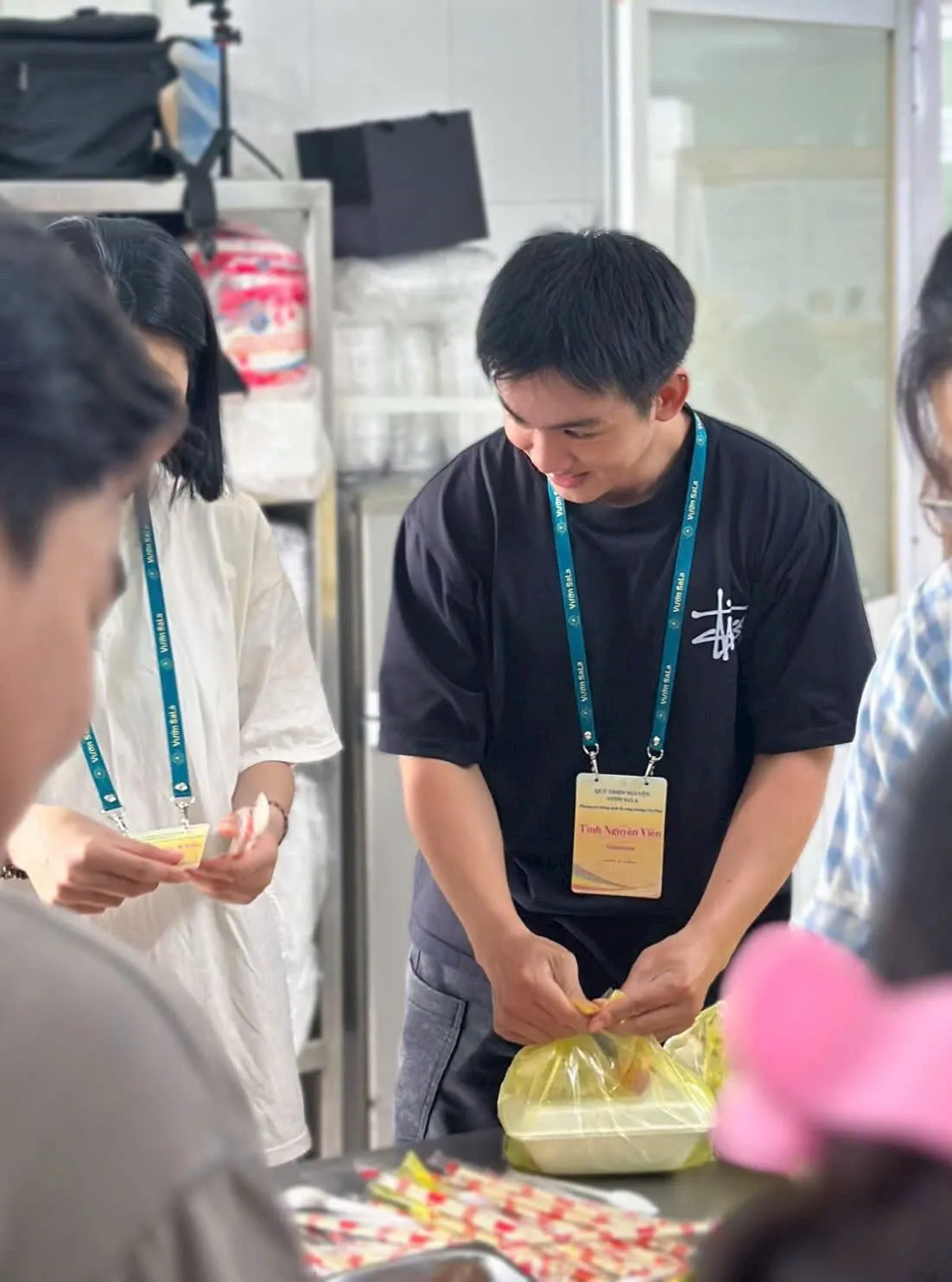 Một bạn tình nguyện viên buộc túi đựng phần cơm