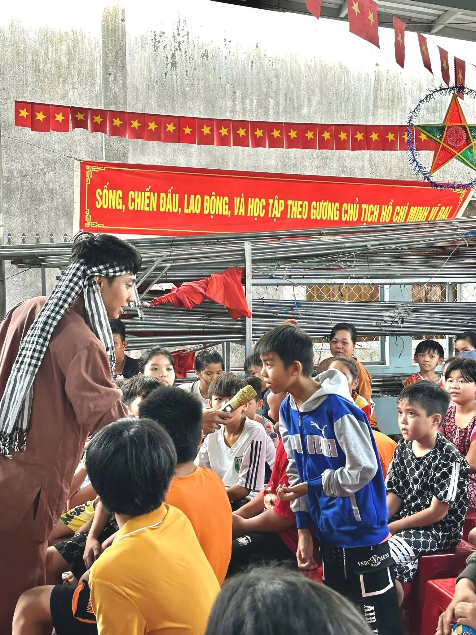 一位志愿者与坐在院子里的孩子们互动