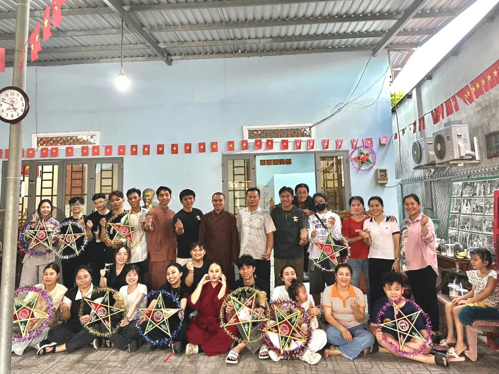 法师、志愿者们与大家的合影，许多人手持五角星灯笼