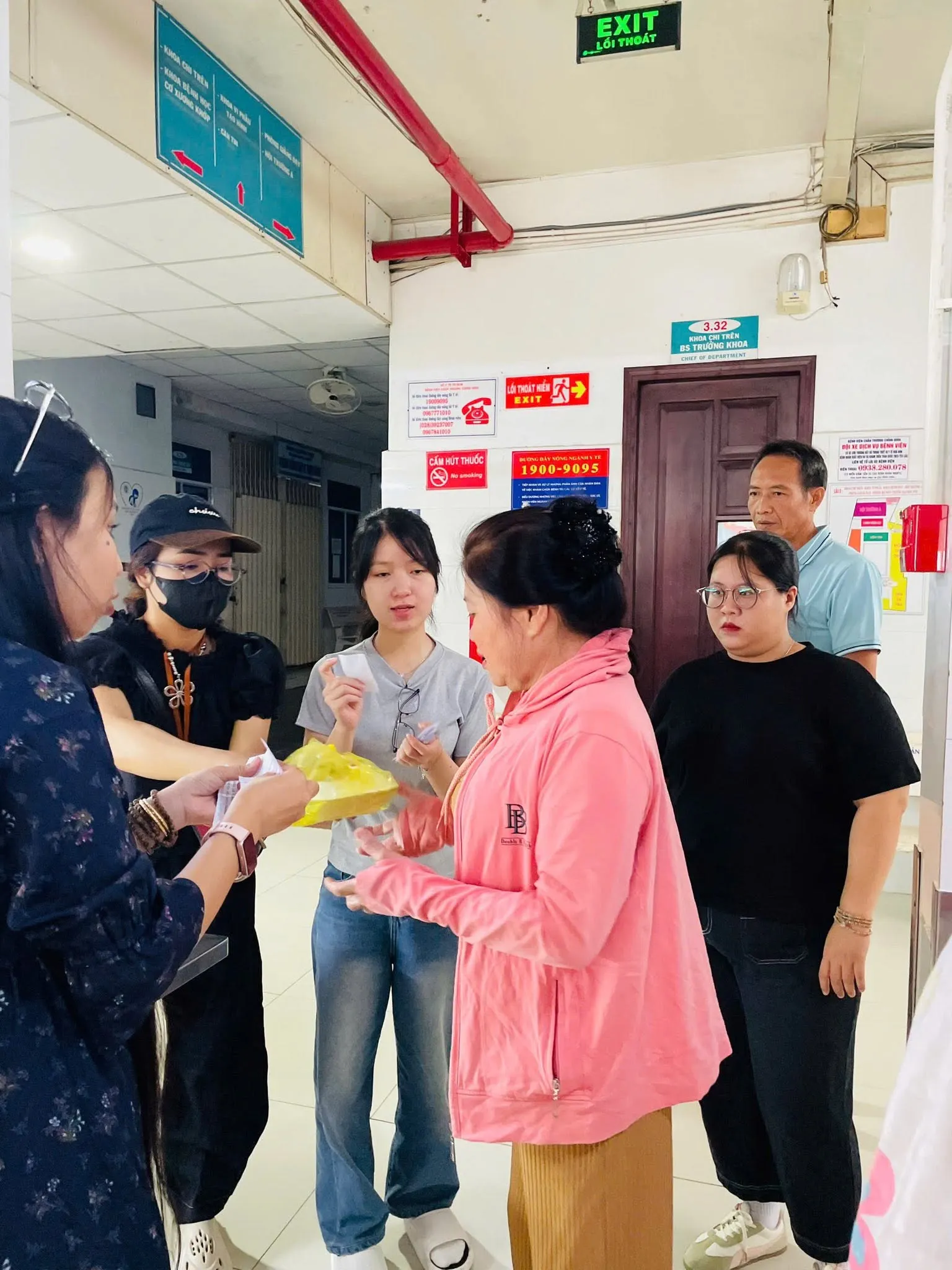一位志愿者把餐食递给一位穿粉色外套的女士