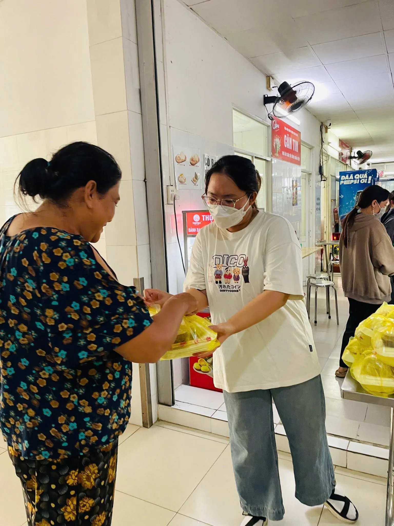 一位志愿者亲手把餐食交给一位女士