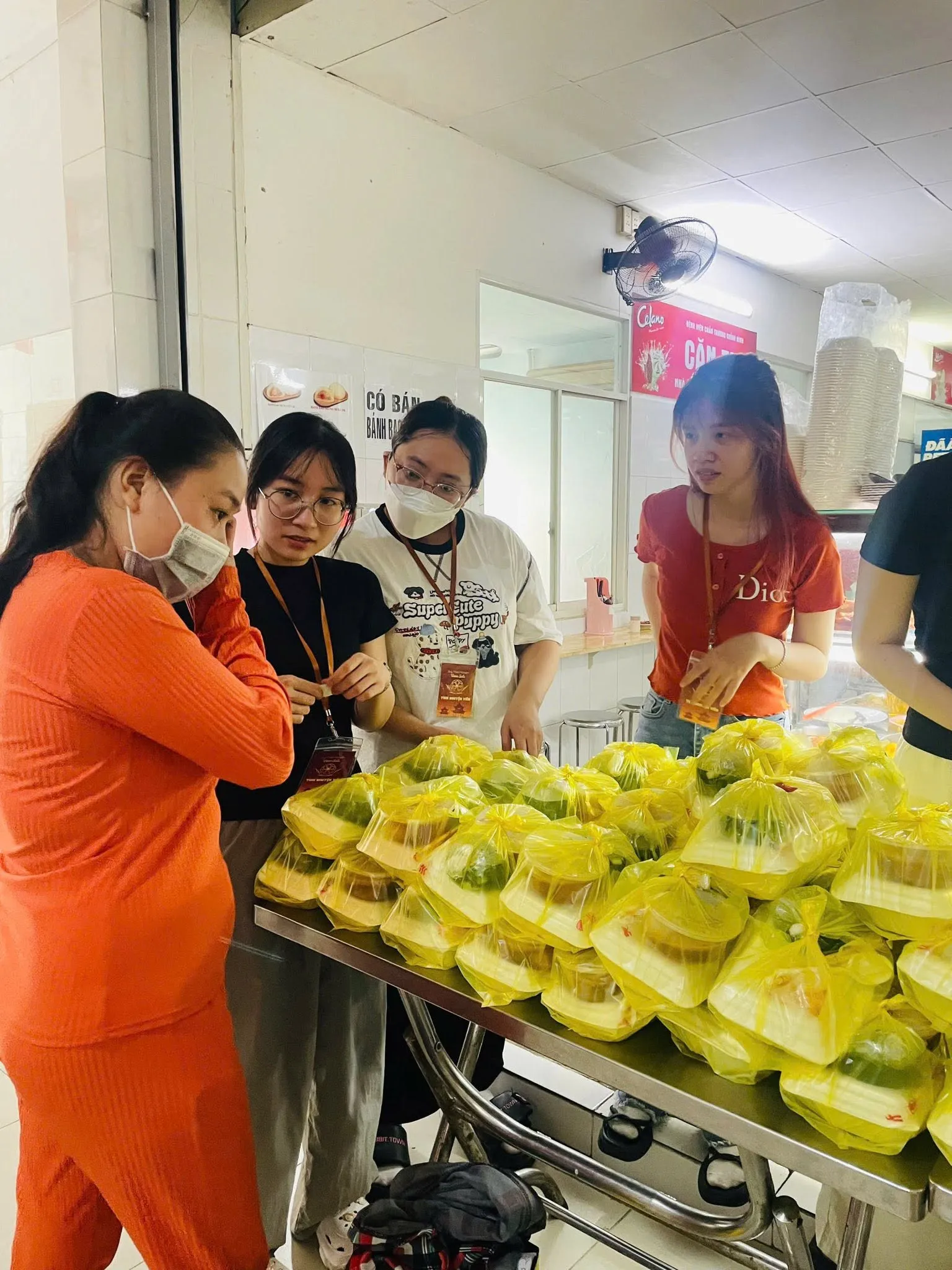 志愿者们与一位阿姨在餐桌旁