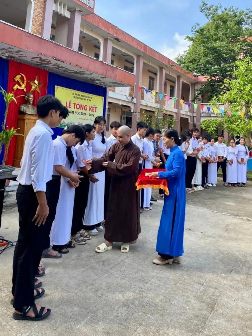 法师依次将奖学金红包递给每一位学生
