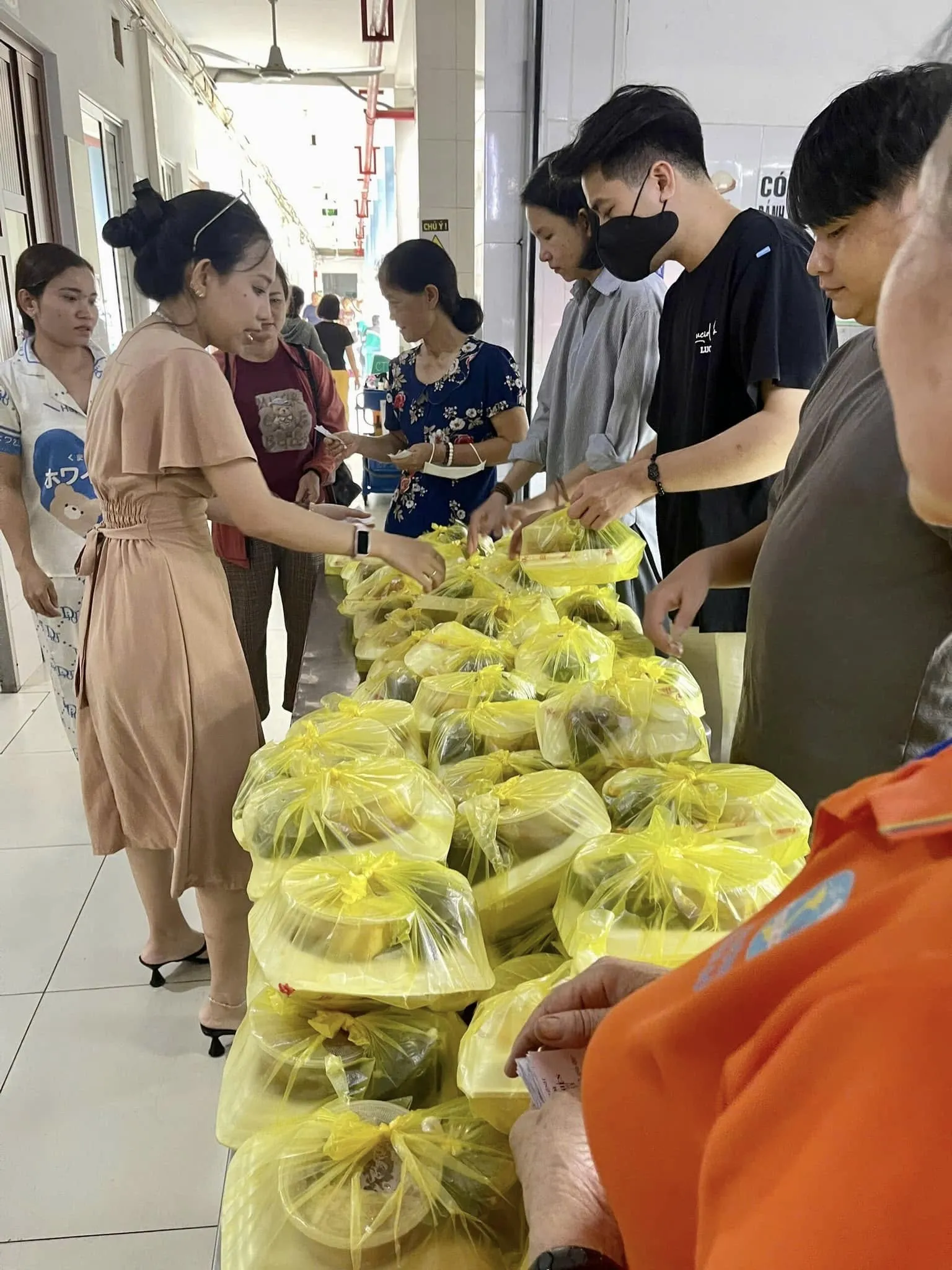 Volunteers arranging the meals, packed in yellow bags, along the table