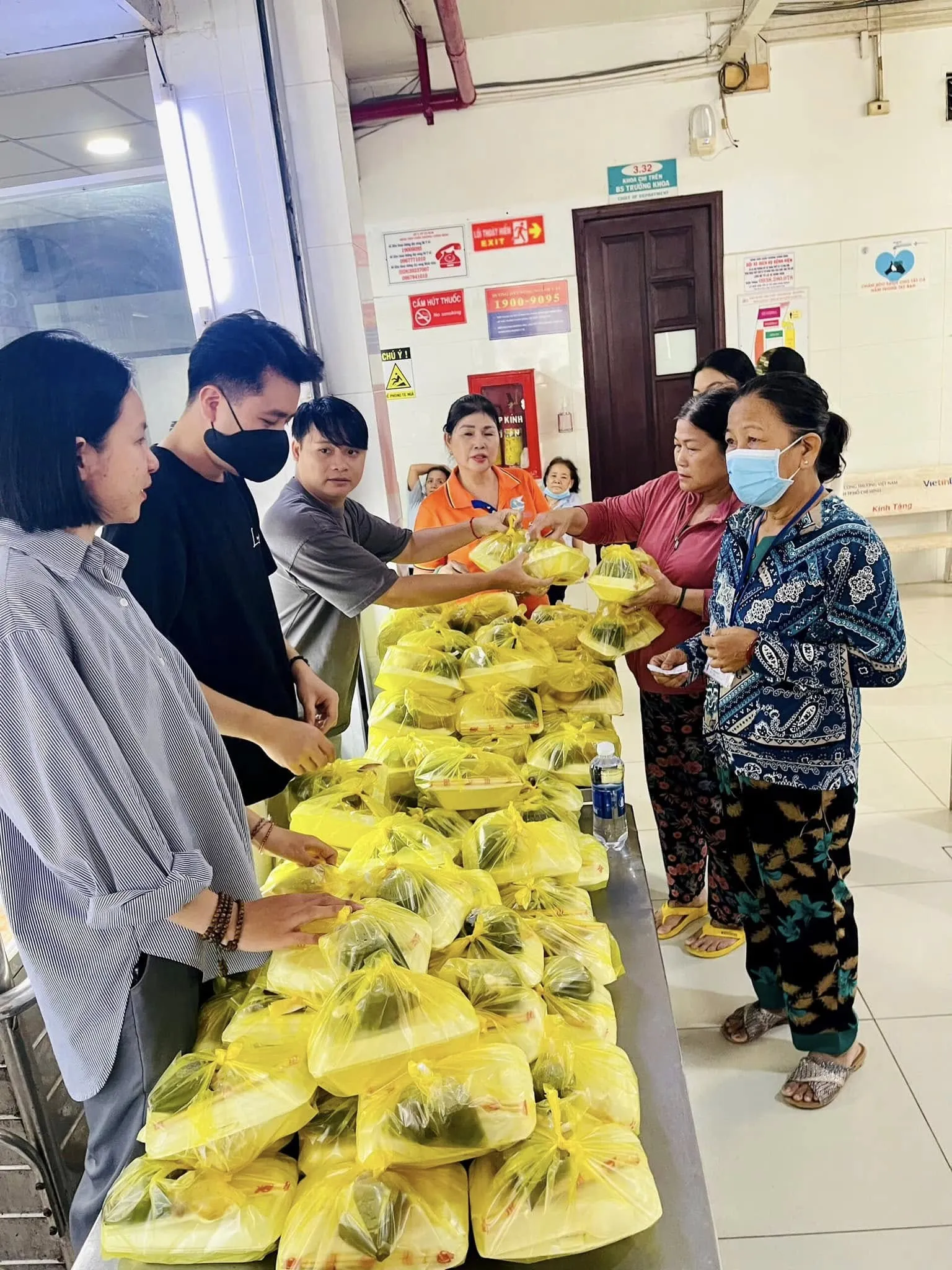 Volunteers handing meals to elderly women in the hospital corridor