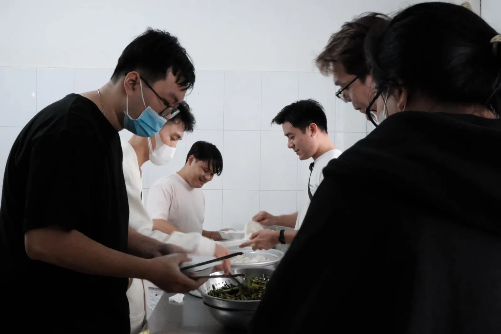 志愿者们在厨房里把饭菜分装进泡沫餐盒