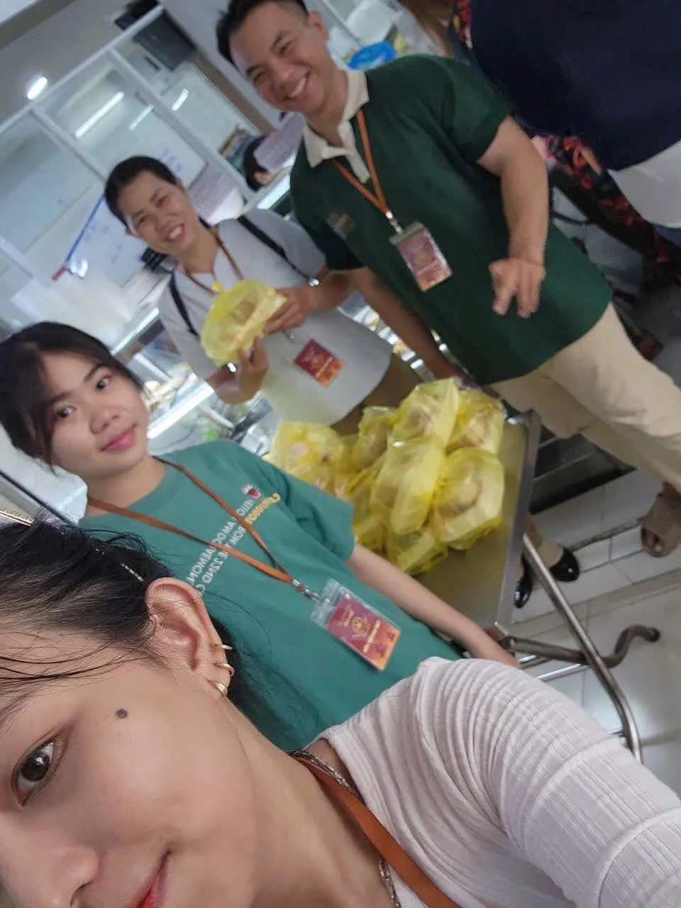 佩戴胸牌的志愿者们笑着在摆满黄色袋装午餐的桌旁自拍