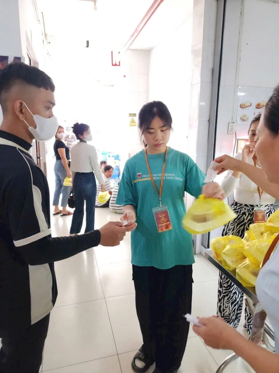 一位志愿者把一袋午餐递给一位戴口罩的年轻人