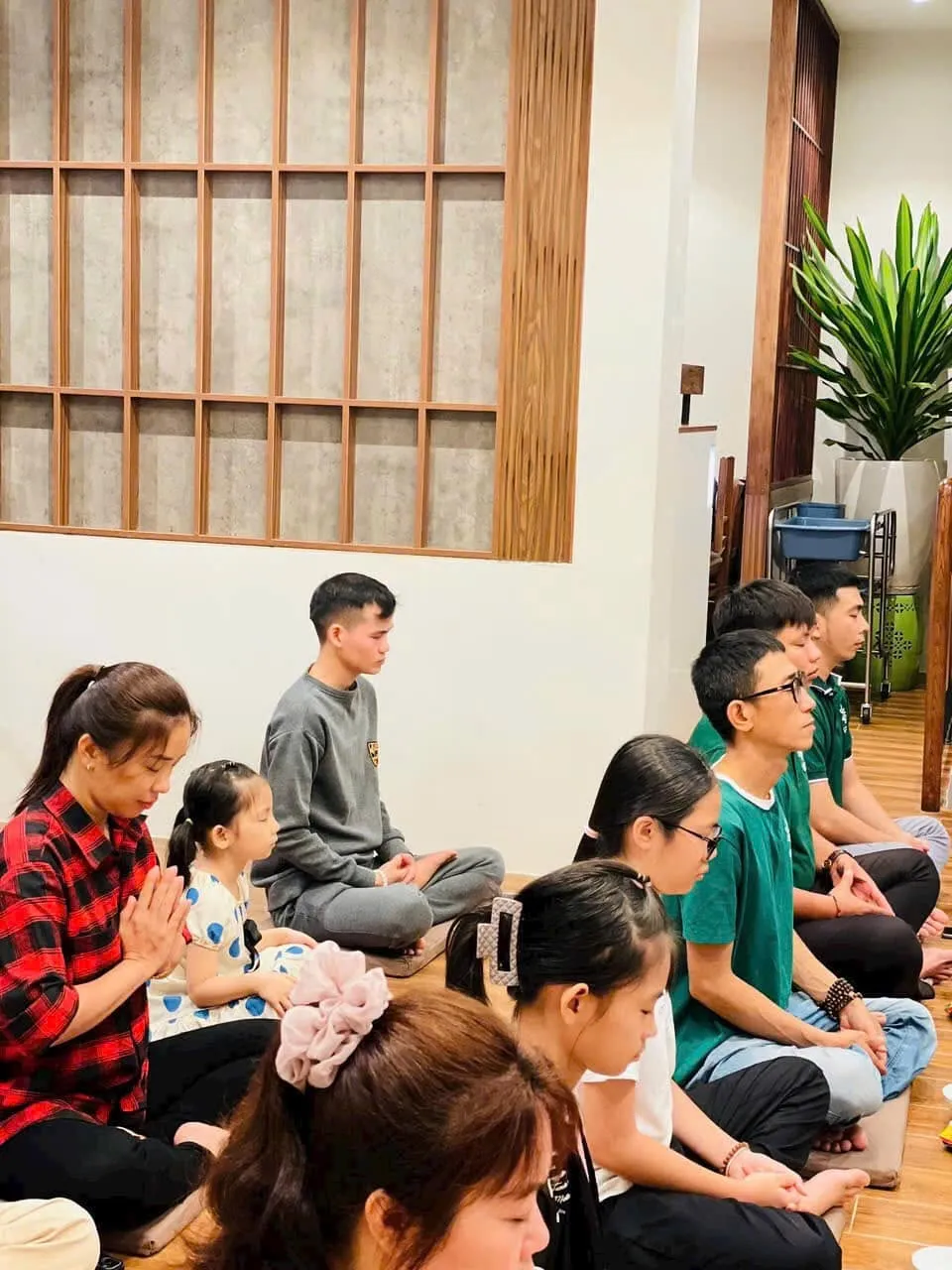 Người tham dự ngồi trên bồ đoàn, chắp tay