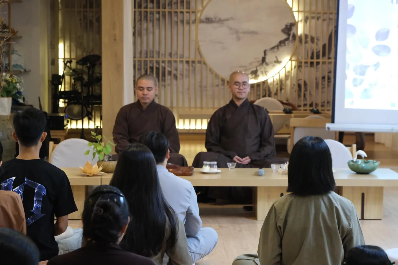 Two monks seated before the gathering at the anniversary