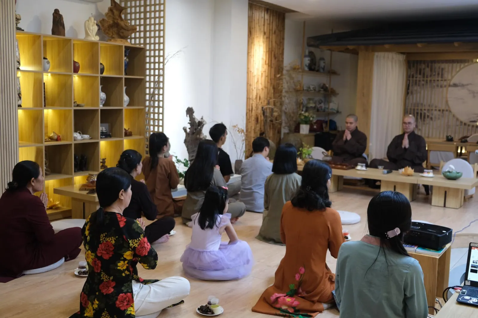 Overview of the anniversary gathering: the attendees seated facing the two monks