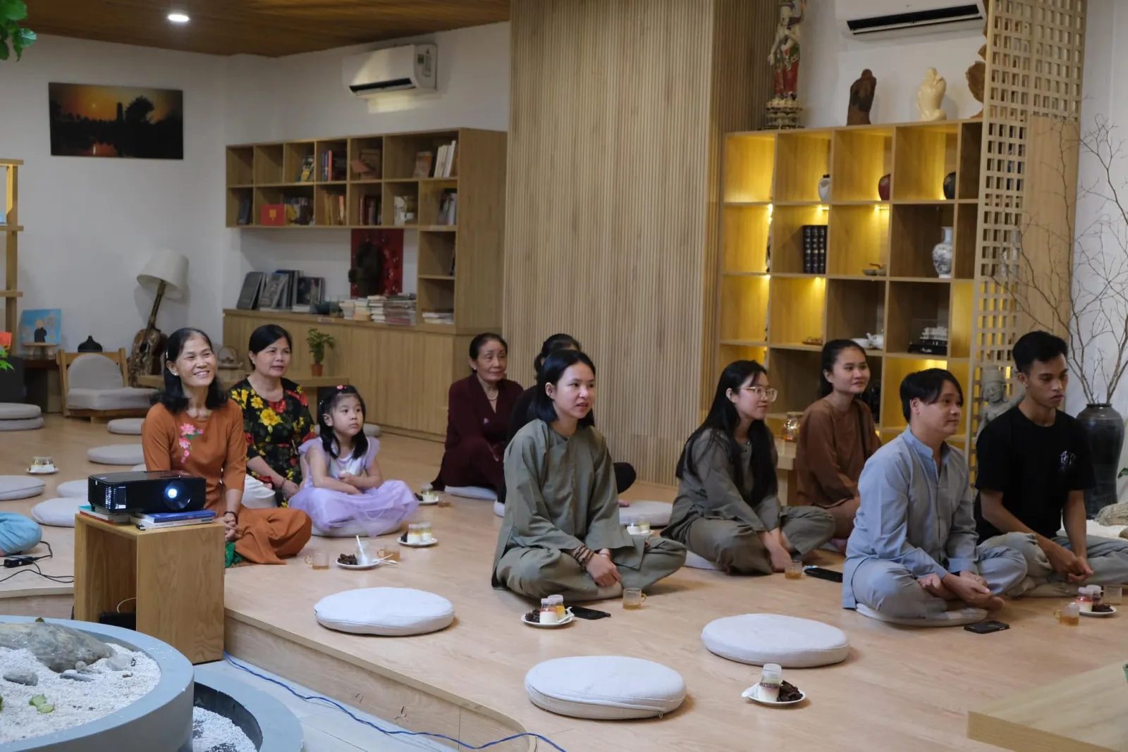 Vườn Sala members, adults and a child, sitting and listening