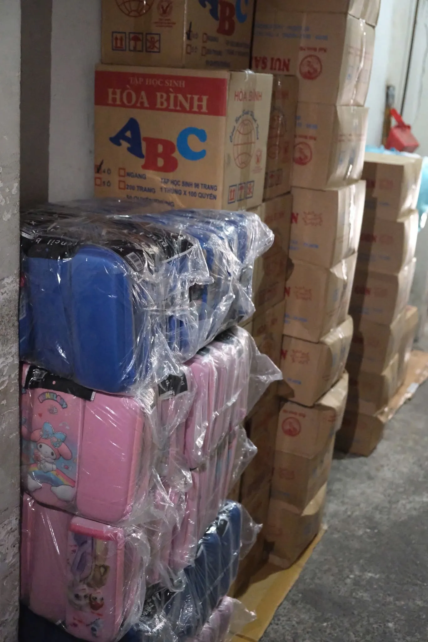 成摞的文具盒与 Hòa Bình ABC 作业本纸箱