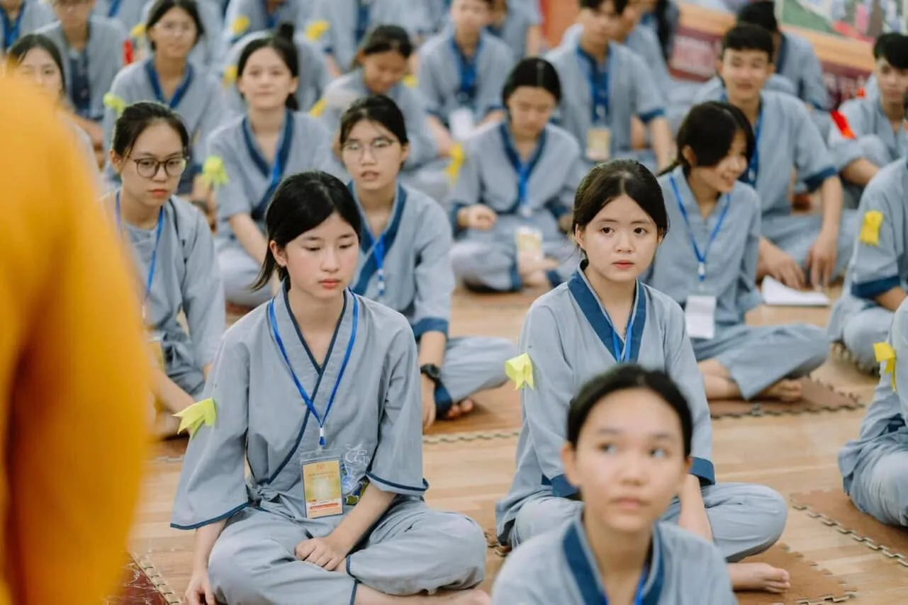 Retreatants sitting on the floor, listening attentively