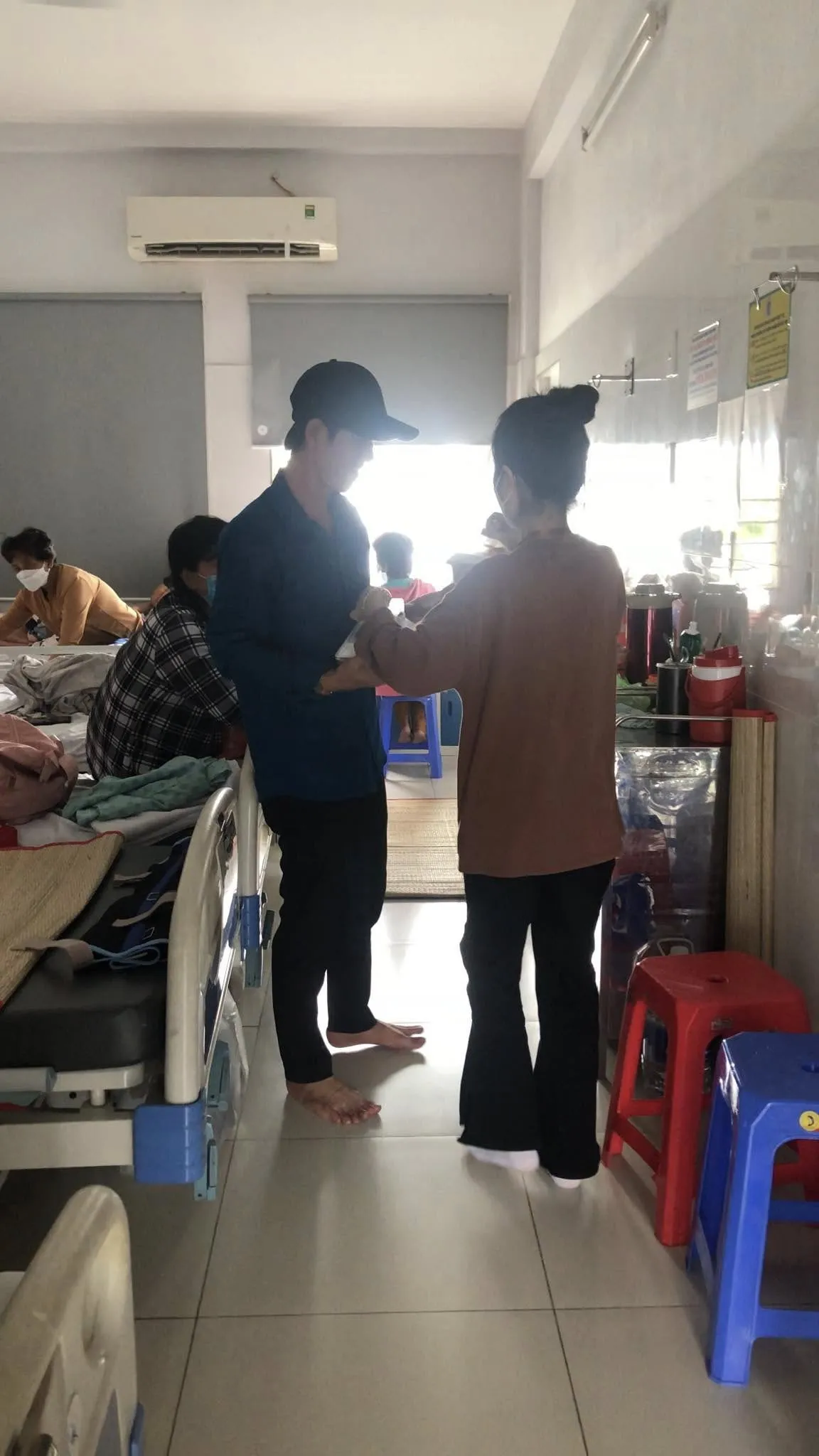 一位志愿者在病房里把餐食递给一个人