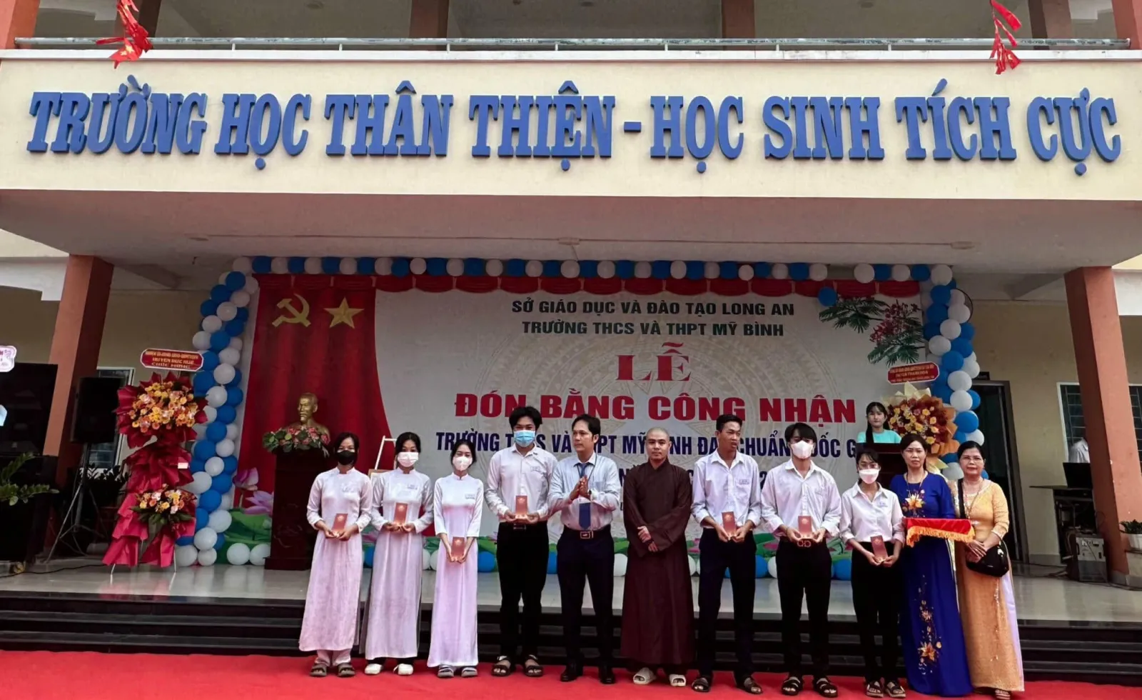 Vườn Sala 慈善基金代表、老师和获得奖学金的学生们在 Trường THCS và THPT Mỹ Bình 舞台上合影
