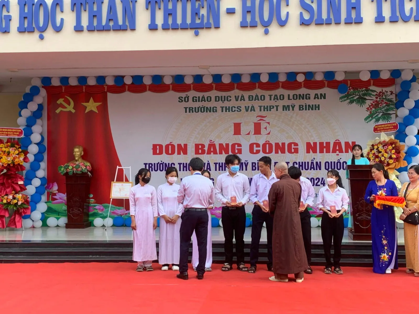 在 Trường THCS và THPT Mỹ Bình 舞台上向学生们颁发奖学金红包