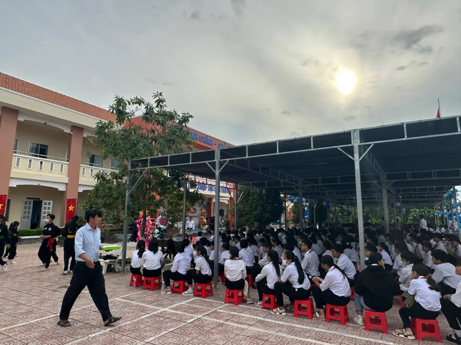 学生们坐在校园遮棚下参加学年总结典礼