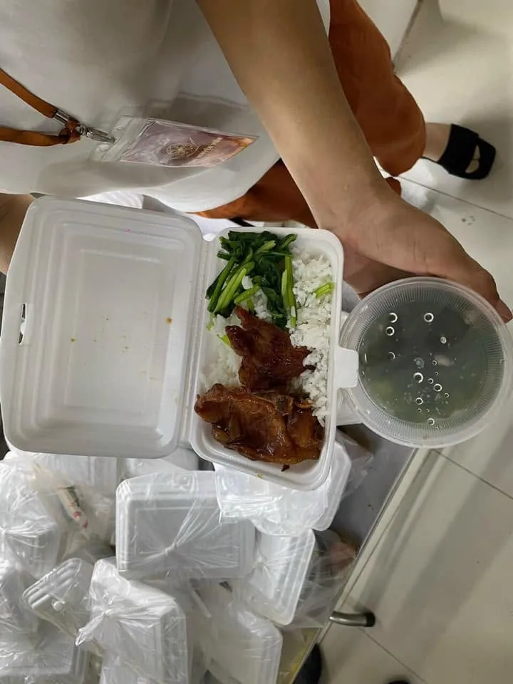 一份泡沫餐盒装的午餐,有米饭、青菜和荤菜,另配一盒汤