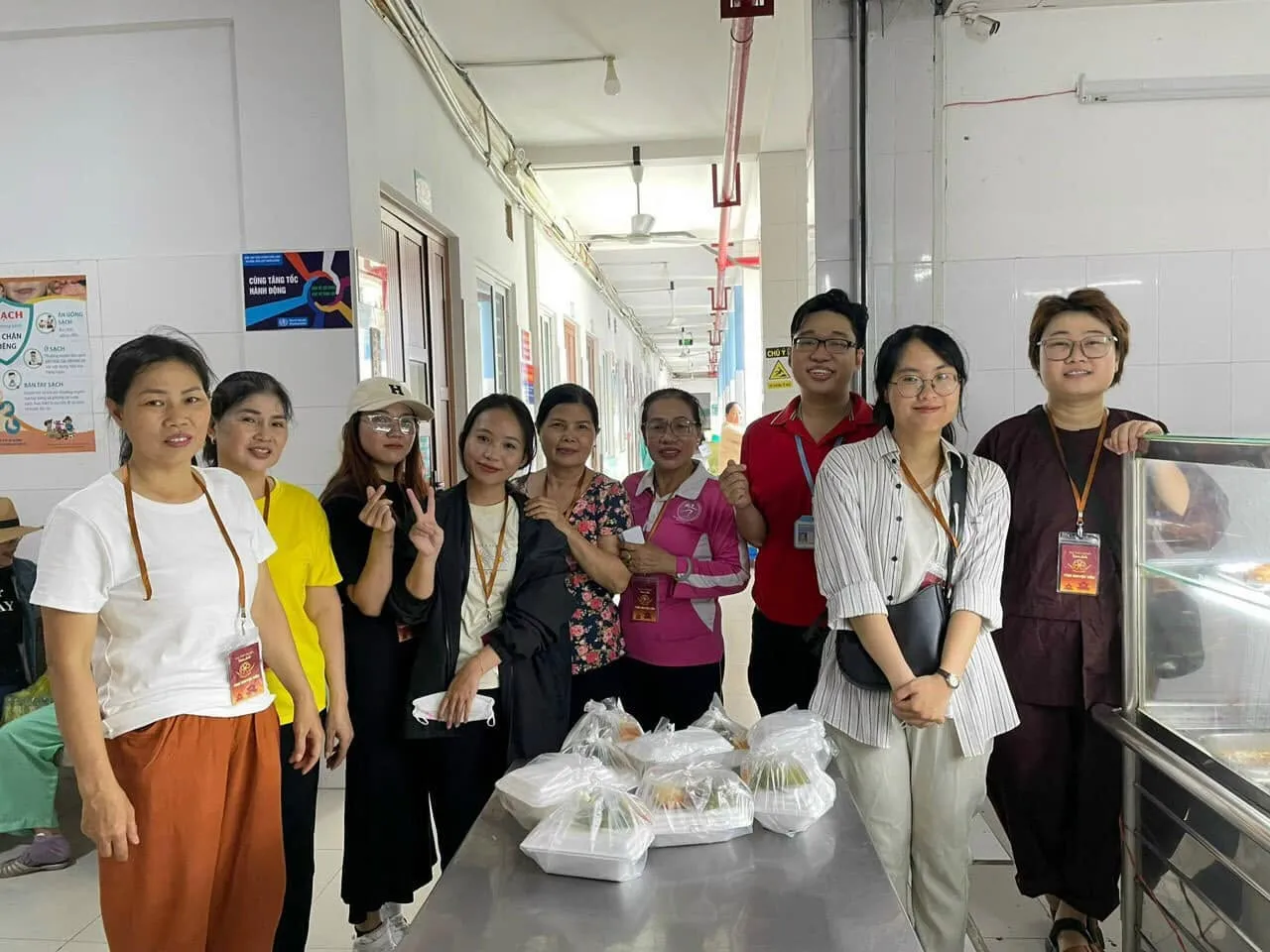 Các bạn tình nguyện viên chụp ảnh chung bên bàn phần ăn trong hành lang bệnh viện