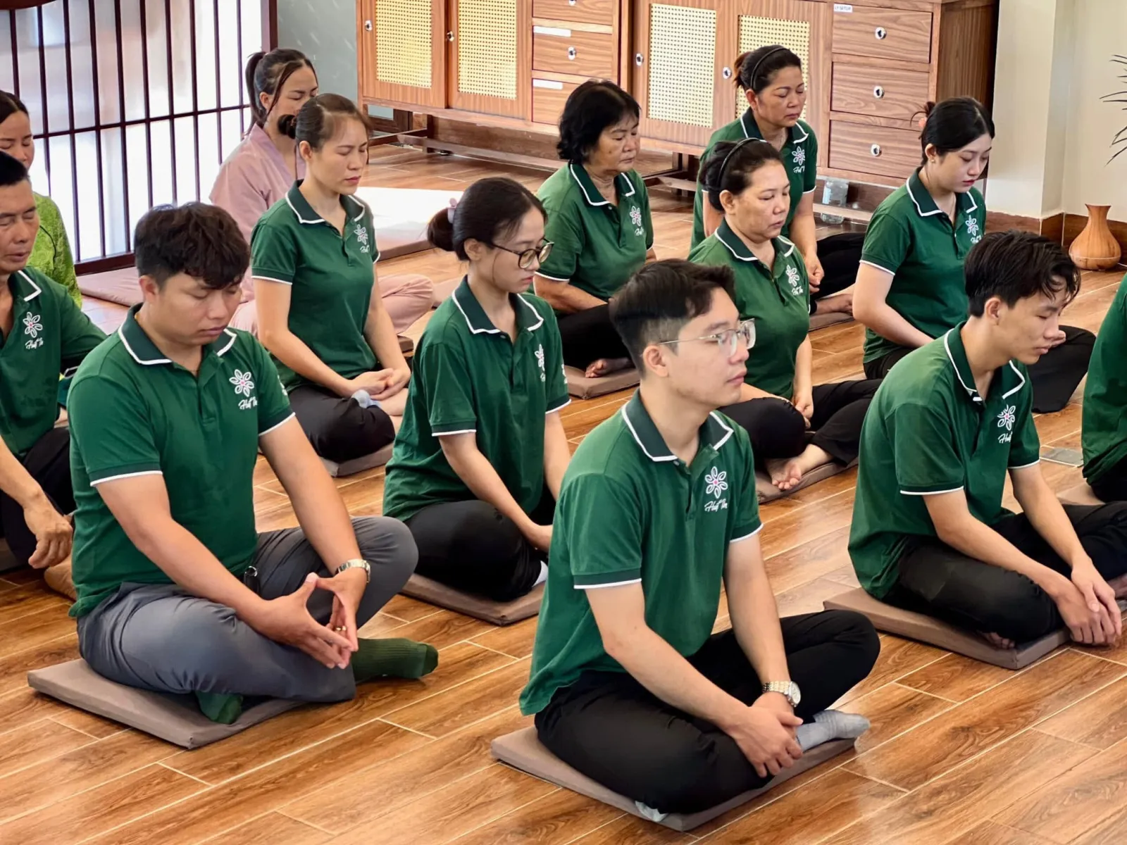 Những người tham dự ngồi xếp bằng, mắt khép lại